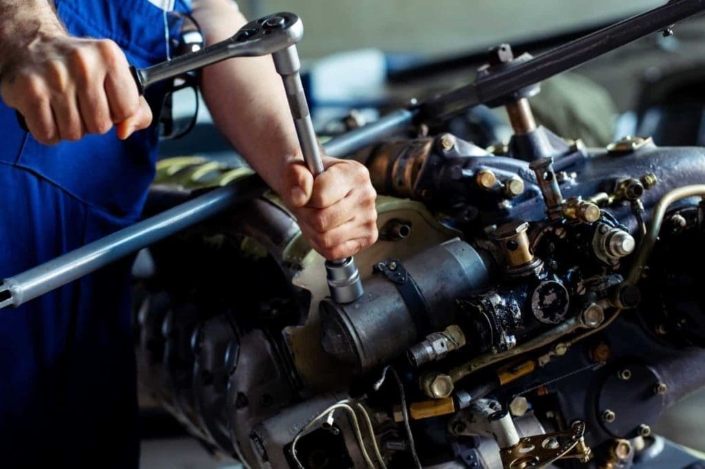 Technician repairing aircraft engine