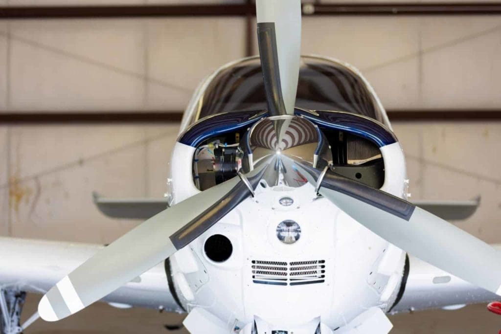 Small white and blue private aircraft in hangar