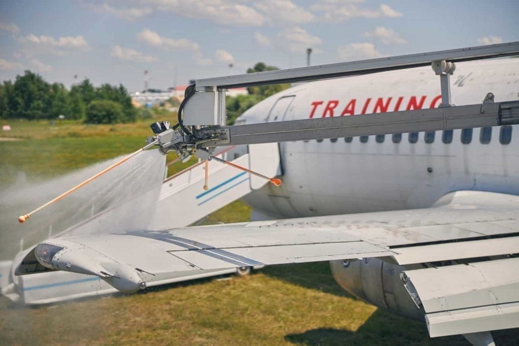 Aircraft technician cleaning off corrosive material on wing