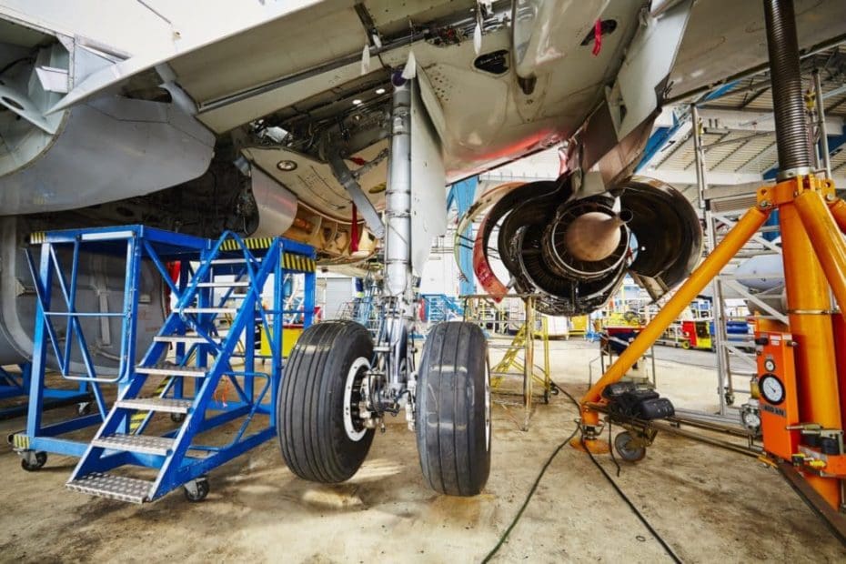 Commercial aircraft with maintenance, repair and overhaul service being performed on landing gear and engine.
